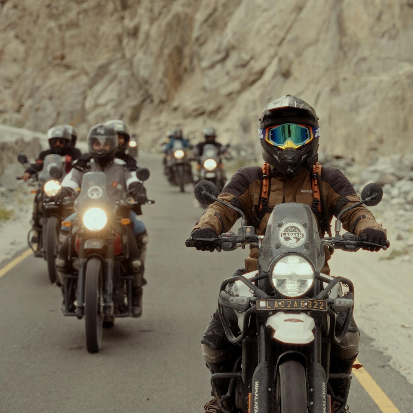 Group of motorcyclists riding through scenic mountain roads, showcasing adventure and freedom.